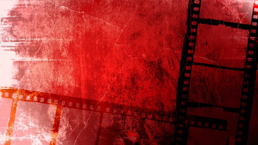 Old film reel against red backdrop.